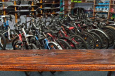Modelleme. Bisikletli spor mağazası görüntüsü. Odaklanamayan, bulanık görüntü. Ön planda ahşap bir masanın üstü, tezgah..