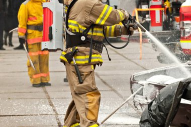 İtfaiyeci yanan arabayı söndürür. İtfaiyecileri eğitiyorum. Gösteri kurtarma çalışması.