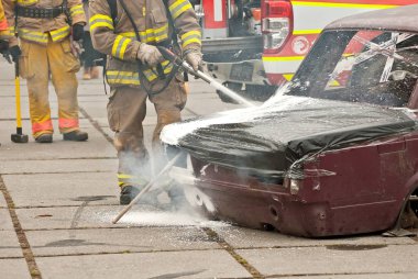 İtfaiyeci yanan arabayı söndürür. İtfaiyecileri eğitiyorum. Gösteri kurtarma çalışması.