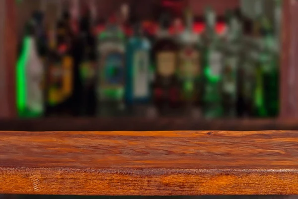 アルコール入りのボトルを背景に木の板 デザインのレイアウトとして古いバーカウンター デザインのためのワークピース 製品を宣伝するための空の場所 背景のバーのぼやけたインテリア — ストック写真