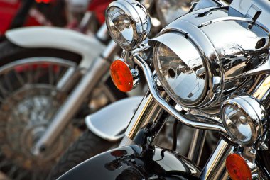 Motosikletler arka arkaya yerleştiriliyor. Farlar yakın çekim. Motosiklet krom elementleri.