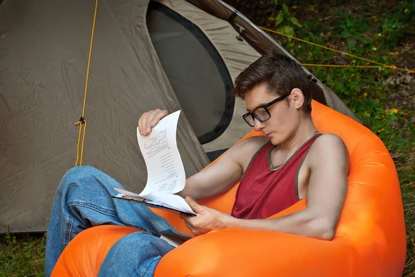 Man Läser Bok Naturen Killen Vilar Orange Hängmatta Nära Tälten — Stockfoto