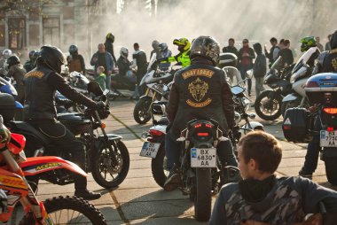 Chernivtsi, Ukrayna, 26 Ekim 2019. Bisiklet Festivali. Şehrin merkez meydanında motosikletçilerle buluşacağız. Birçok insan motosiklet şovları izler. Sokak dumanlı. İnsan siluetleri.