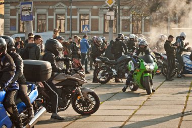 Chernivtsi, Ukrayna, 26 Ekim 2019. Bisiklet Festivali. Şehrin merkez meydanında motosikletçilerle buluşacağız. Birçok insan motosiklet şovları izler. Sokak dumanlı. İnsan siluetleri.