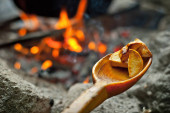 Brambory se vaří ve velkém kotli v ohni. Jídlo se vaří na táborovém ohni v pochodových podmínkách.