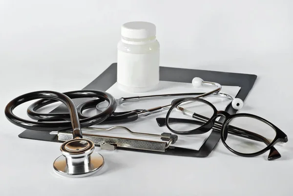 Sprzęt Medyczny Białym Tle Stetoskop Okulary Czarnym Folderze Biała Butelka — Zdjęcie stockowe