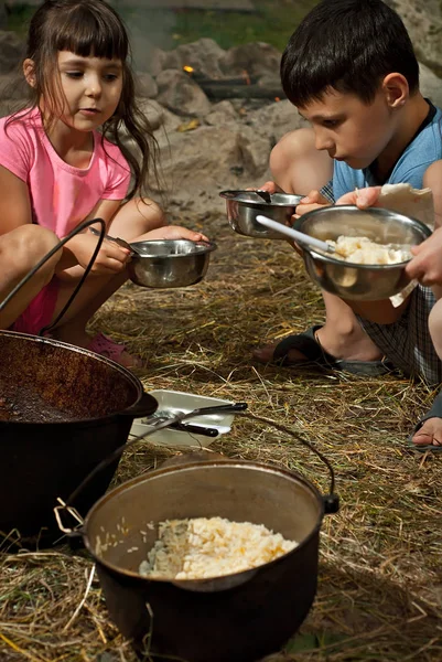 Çocuklar Kamp Gezisinde Yemek Yiyor Kazanın Içindeki Yemek Ateşte Pişiyor — Stok fotoğraf