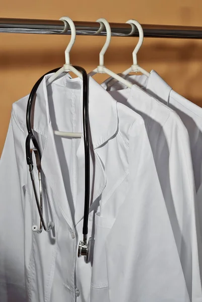 Witte Medische Jurken Hangen Aan Hangers Kleding Met Stethoscoop Oranje — Stockfoto