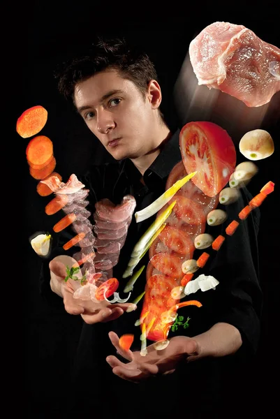 셔츠를 남자가 어두운 배경에서 음식을 도마도 채소들이 날아다닌다 예술적 효과로 — 스톡 사진
