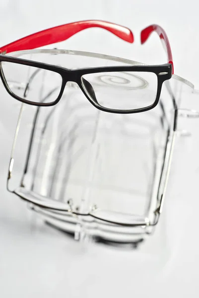 白い背景に多くの眼鏡 透明な店内の窓には眼鏡がかけられている 灰色のテーブルの上にガラススタンド 光学の販売及び展示 — ストック写真