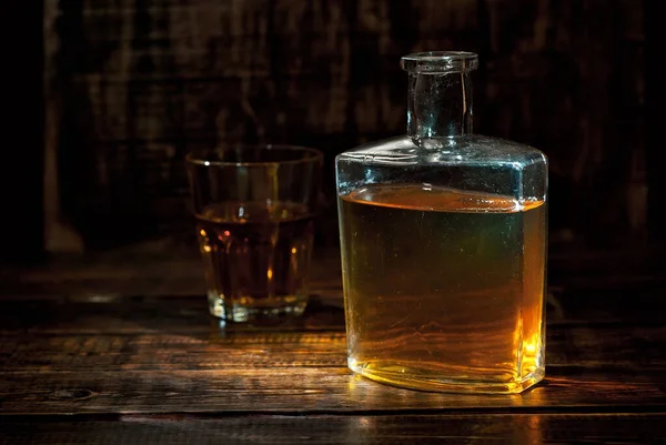 Szklankę Alkoholu Pobliżu Butelki Stara Butelka Whisky Czarnym Drewnianym Stole — Zdjęcie stockowe