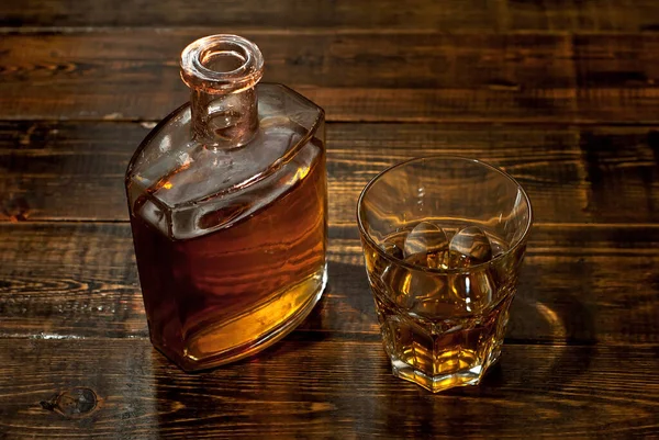 Ένα Ποτήρι Αλκοόλ Κοντά Ένα Μπουκάλι Παλιό Μπουκάλι Ουίσκι Μαύρο — Φωτογραφία Αρχείου
