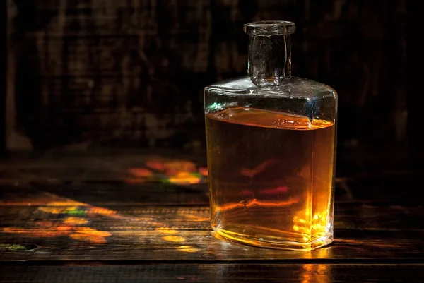 老酒瓶 威士忌放在黑色木制桌子上 在黑暗模糊的背景上喝酒 — 图库照片