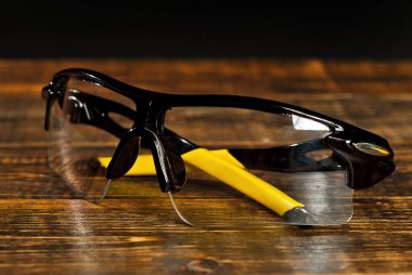 Siyah arka planda temiz camlı bisiklet gözlükleri. Eski kahverengi bir tahtada spor gözlükleri..