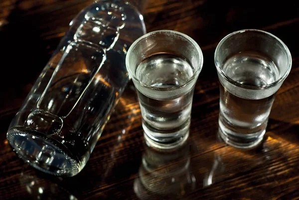 Mrożone Szklanki Alkoholem Pobliżu Butelki Drinki Ciemnobrązowym Stole Przezroczyste Naczynia — Zdjęcie stockowe