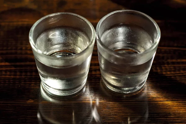 Δύο Παγωμένα Ποτήρια Από Κοντά Ποτήρια Αλκοόλ Μαύρο Ξύλινο Τραπέζι — Φωτογραφία Αρχείου