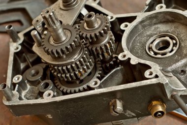 Motoru motosikletten sökülmüş. Eski yedek parçaların onarımı ve bakımı.