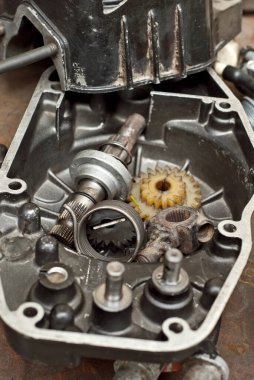 Motoru motosikletten sökülmüş. Eski yedek parçaların onarımı ve bakımı.