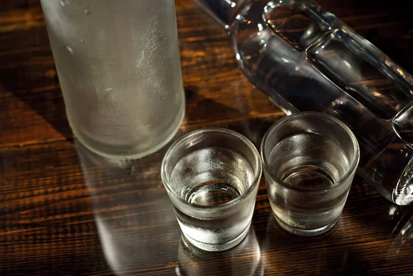 Παγωμένα Ποτήρια Αλκοόλ Κοντά Στο Μπουκάλι Ποτά Σκούρο Καφέ Τραπέζι — Φωτογραφία Αρχείου
