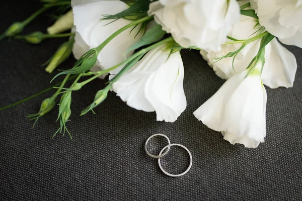 회색 배경에 흰색 꽃에 황금 결혼 반지 — 스톡 사진