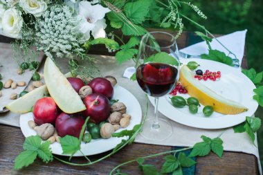 Lezzetli meyveler ve bir bardak kırmızı şarap ile akşam yemeği için servis tablo