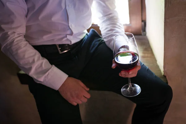 Bräutigam hält ein Glas Rotwein in der Hand lizenzfreie Stockfotos