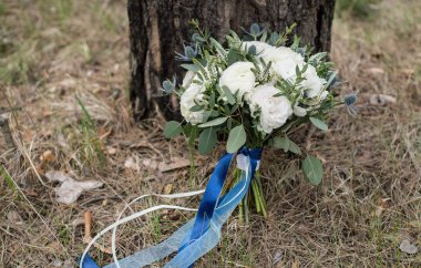 Beyaz düğün düğün buket ipek mavi şeritler ağaç üzerinde desteklenen