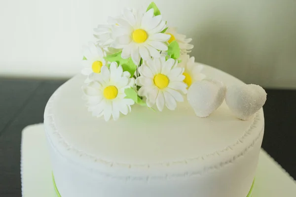 La decoración de manzanilla y el corazón en el pastel de boda blanco de la almáciga —  Fotos de Stock