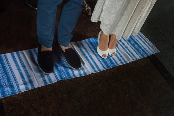 Frischvermählte auf dem Handtuch stehend. Verlobungszeremonie in der Ukraine Stockfoto