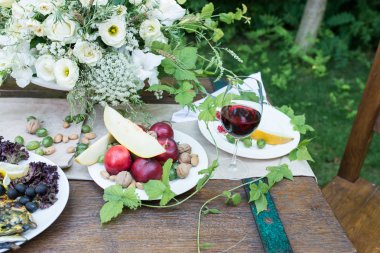 Bir bardak kırmızı şarap, kırmızı kuş üzümü, bektaşi üzümü, ızgara sebzeler ile servis tablo
