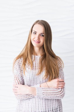 Gülümseyen modeli kadın uzun saçlı beyaz bir arka plan üzerinde kameraya bakıyor