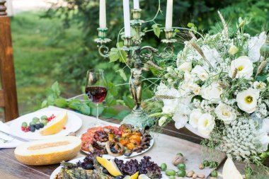 Kavun, ızgara sebze, kadeh kırmızı şarap ve meyve ile hizmet tablo 