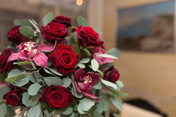 Arreglo de bodas con rosas rojas, orquídeas y eucaliptos en la mesa del banquete —  Fotos de Stock