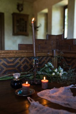 Ahşap üzerinde bir şamdan içinde yanan bir kahverengi mum. Sabah gelin. Alt dantelli beyaz iç çamaşırı. Parfüm