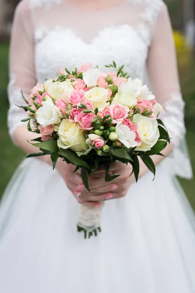Ramo de novia con rosas blancas y rosas rosadas. Boda. La novia en vestido de novia blanco sostiene un ramo de boda con rosas blancas y rosas rosadas, vegetación . — Foto de Stock
