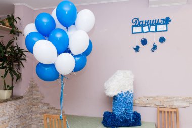 Çocuk bir yıl önce alınmış. Balonlar, bir oyuncak ve büyük bir renkli kağıt ile dekore parlak çocuk odası.