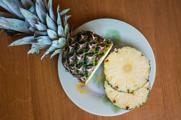Ананасовые фрукты с нарезанными фруктами ананаса на деревянном столе . — стоковое фото