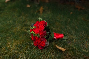 Düğün buket kırmızı gül yeşil çim üzerinde yalan