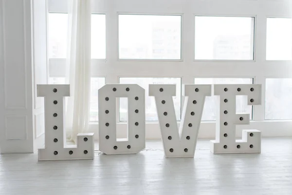 Love is a gift, Love Valentines day. Love along with light. Bulb light on the letter of love.  Vintage marquee light love letter sign. A wooden lettering Love with light bulbs.