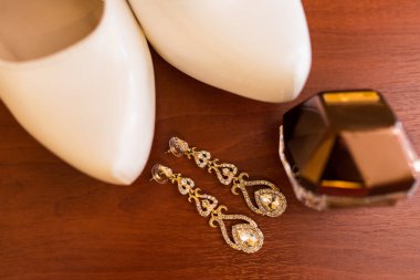 Odak, değerli taşlar ile gelin küpe altın şişe, topuklu parfüm. Düğün aksesuarları.