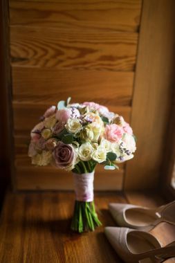 Düğün buket pembe Şakayık, sarı, pembe Gül ve yeşillik zarif gelin ayakkabıları ile. Düğün detayları 