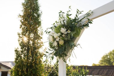 Güzel düğün kemer ile taze beyaz çiçekler ve bahçede yeşil parçası