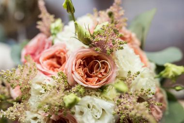 Altın alyans pembe Gül bir tomurcuk içinde yalan. Alyans yalan üzerine bir çiçek tomurcuk