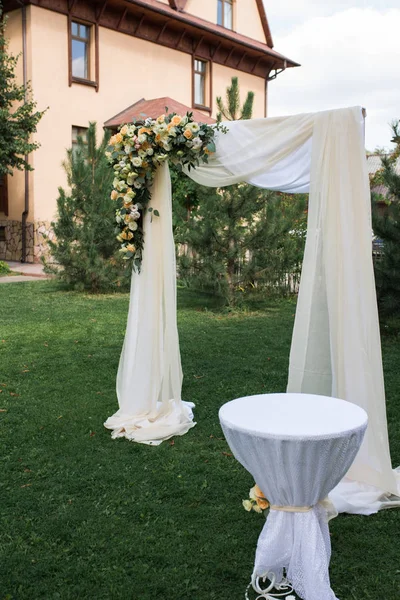 オープンエアをあしらったベージュ素材と新鮮な花で飾られた木製アーチ結婚式のための領域 美しい結婚式を設定します 庭に緑の芝生の上の結婚式 結婚の場所の登録 — ストック写真