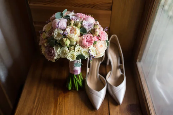 Düğün buket pembe Şakayık, sarı güller ve yeşillik zarif gelin ayakkabıları ile. Düğün