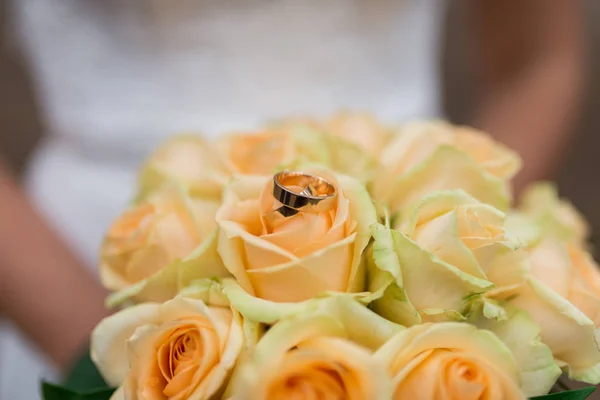 Golden wedding rings lie in a bud of yellow rose. Wedding rings lie on a flower bud