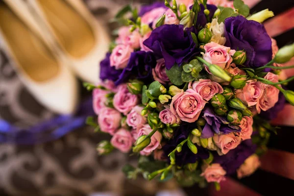 Wedding bouquet with purple and pink roses, violet flowers close up.