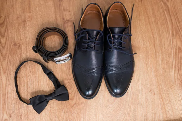 Grooms black accessories: leather belt, necktie, shoes. Wedding
