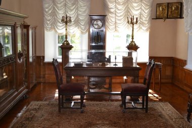 Tablo ve bir kitaplık yakın iki koltuk eski oda. Oda iç.