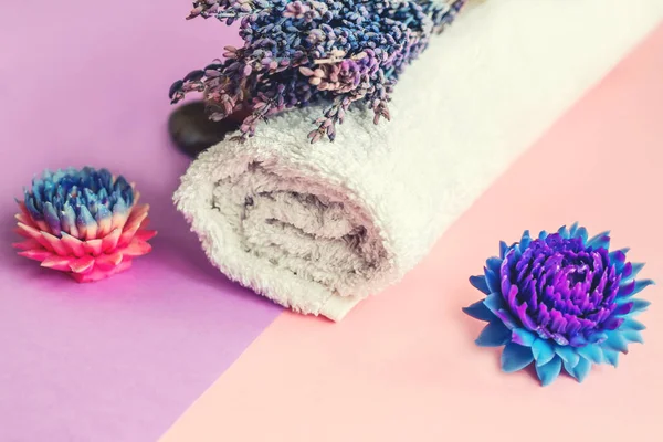 Beautiful soap in the form of flowers and towel with lavender flowers for Spa treatments on a two-tone background. Selective focus.